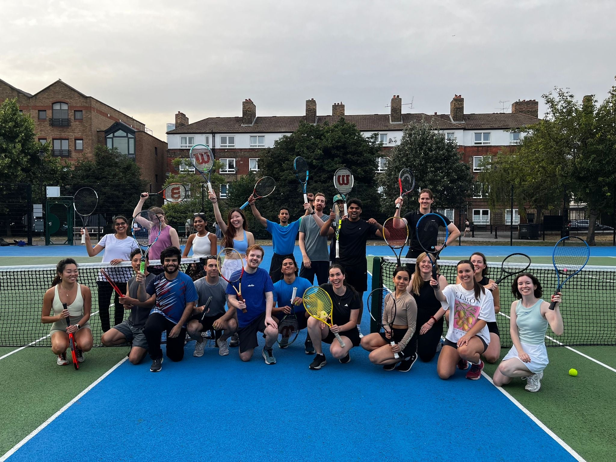 Net Socials London social tennis club  on a tennis court with tennis rackets
